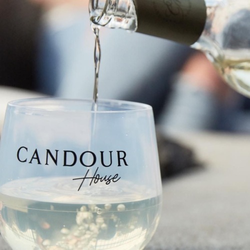 a hand pouring a liquid into a glass