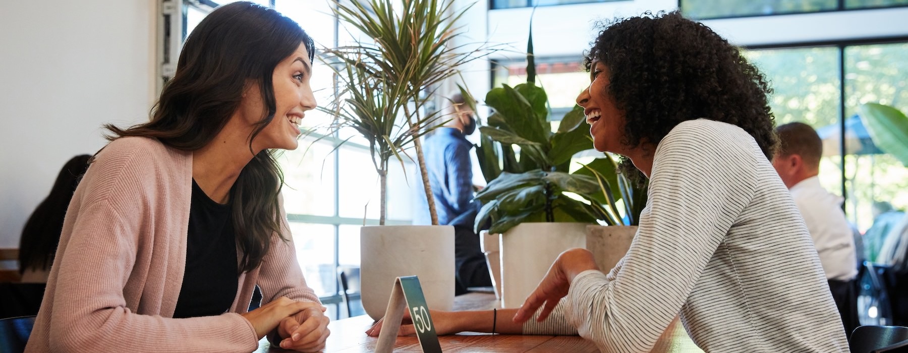 two women talking at a table