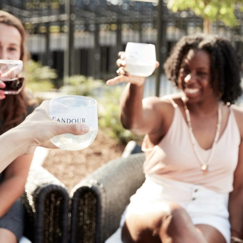 a group of women sitting at a fireplace with drinks